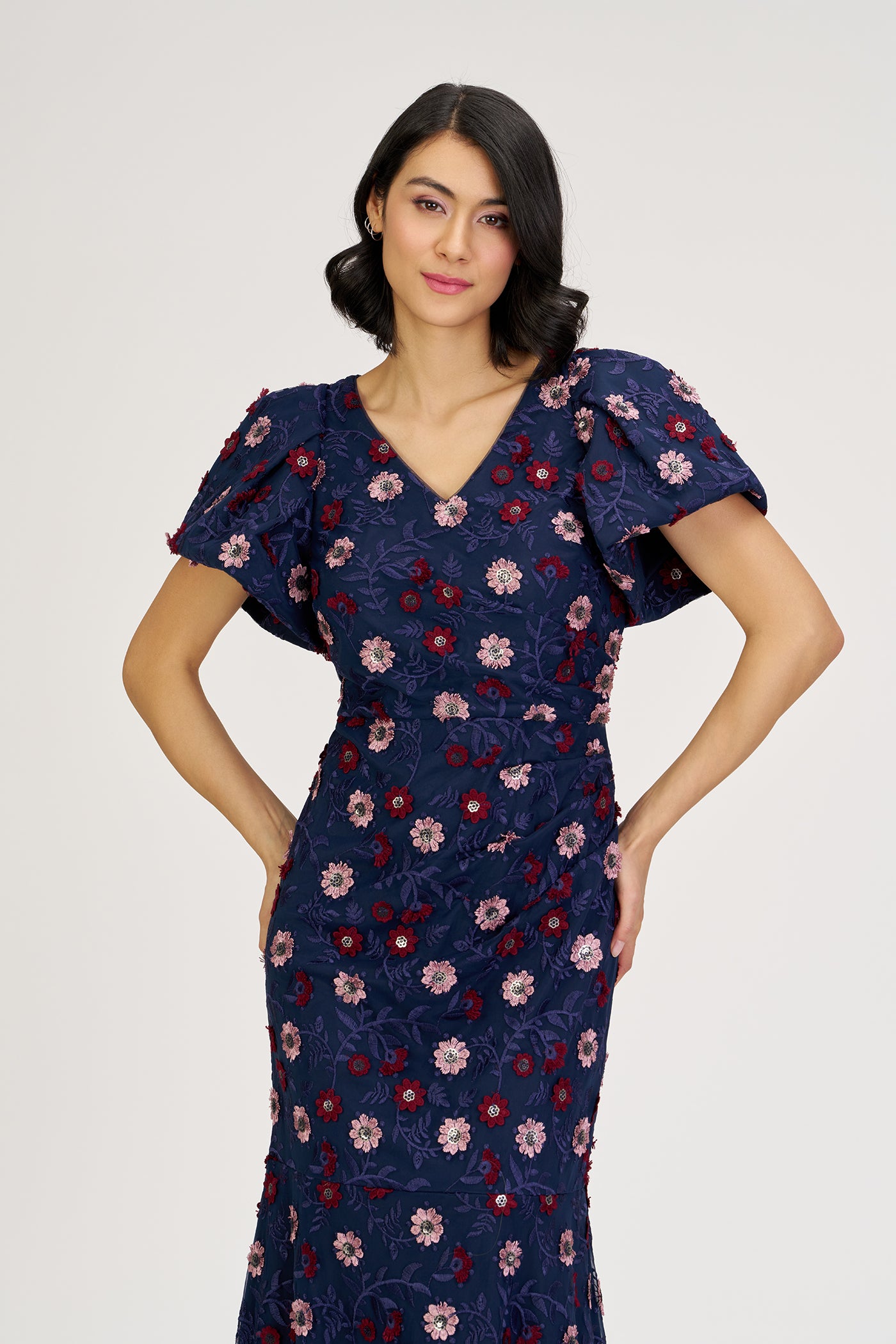 Woman wearing a navy floral dress against a white background