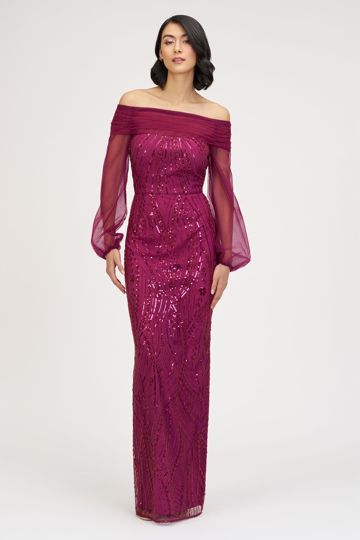 Woman wearing a burgundy off-shoulder evening gown with sequin detailing on a white background