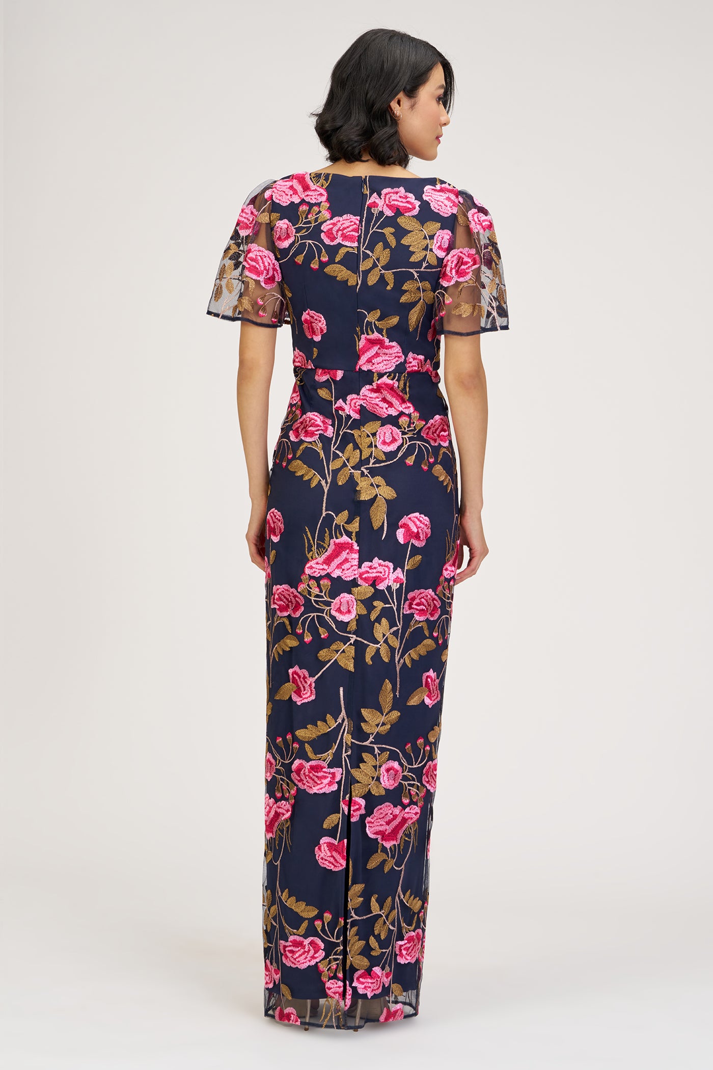 Woman wearing a floral dress with pink flowers on a white background