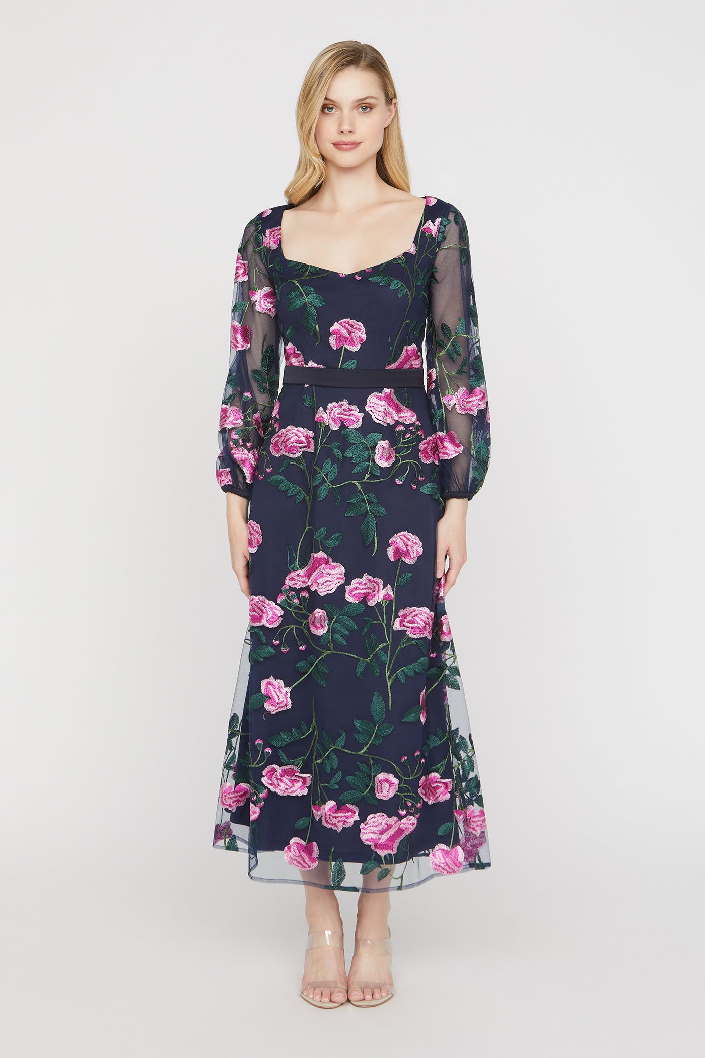 Woman wearing a floral dress with pink flowers on a white background