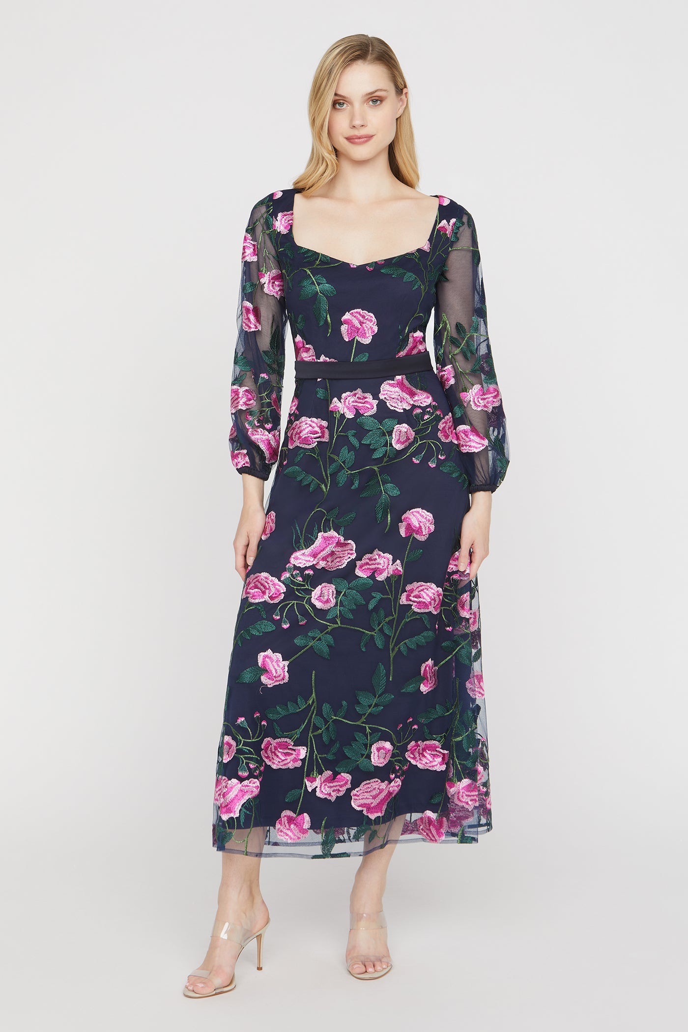 Woman wearing a floral dress with pink flowers on a white background