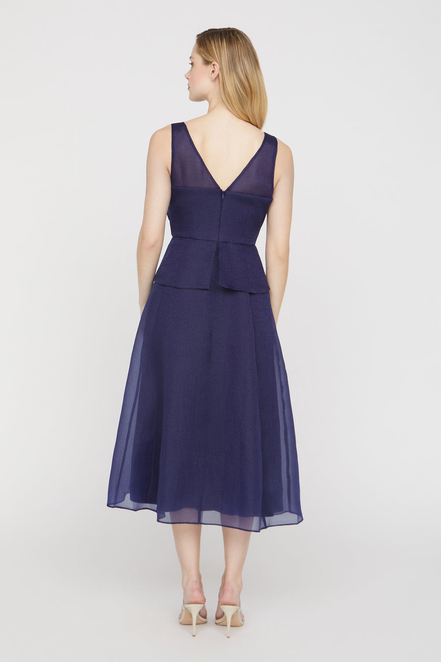 Navy blue dress with a peplum waist on a white background
