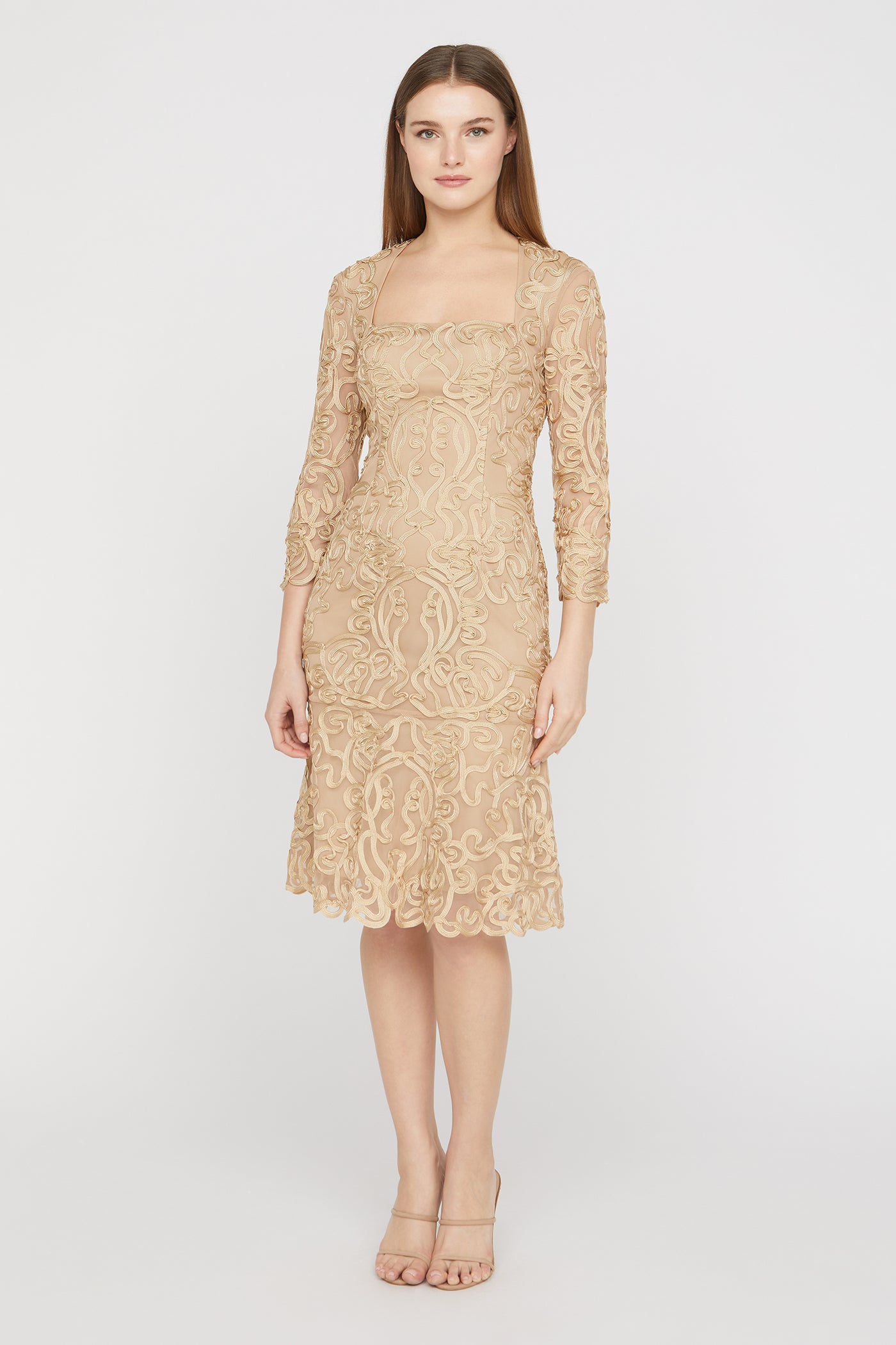 Woman wearing a beige lace dress on a white background