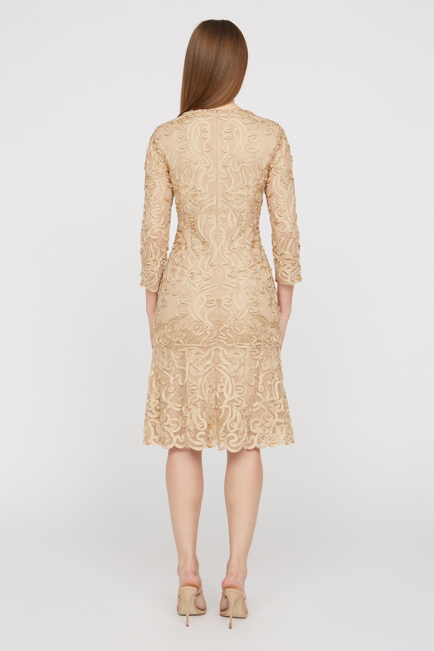 Beige lace dress worn by a model on a white background