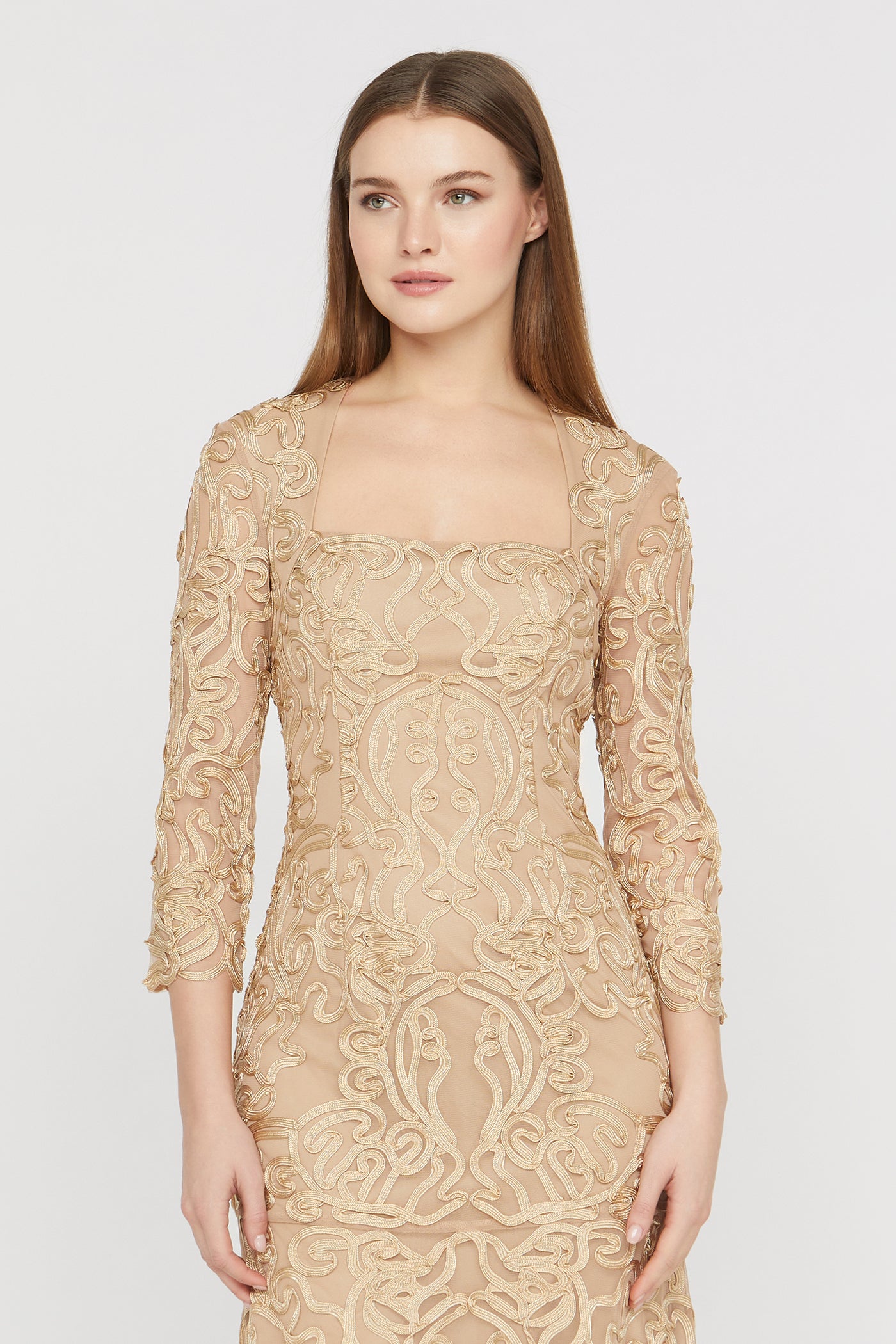 Woman wearing a beige lace dress on a white background
