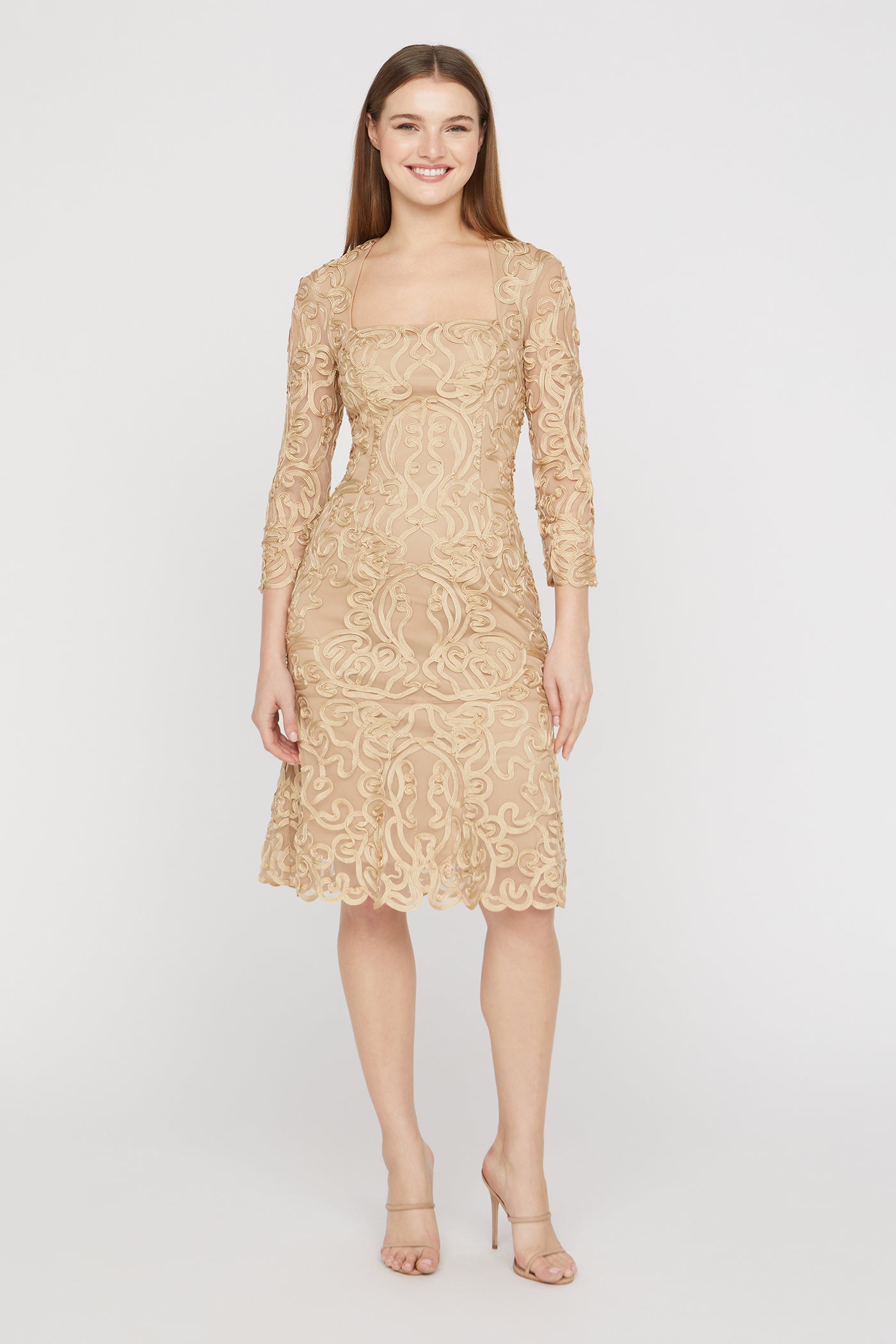 Woman wearing a beige lace dress on a white background