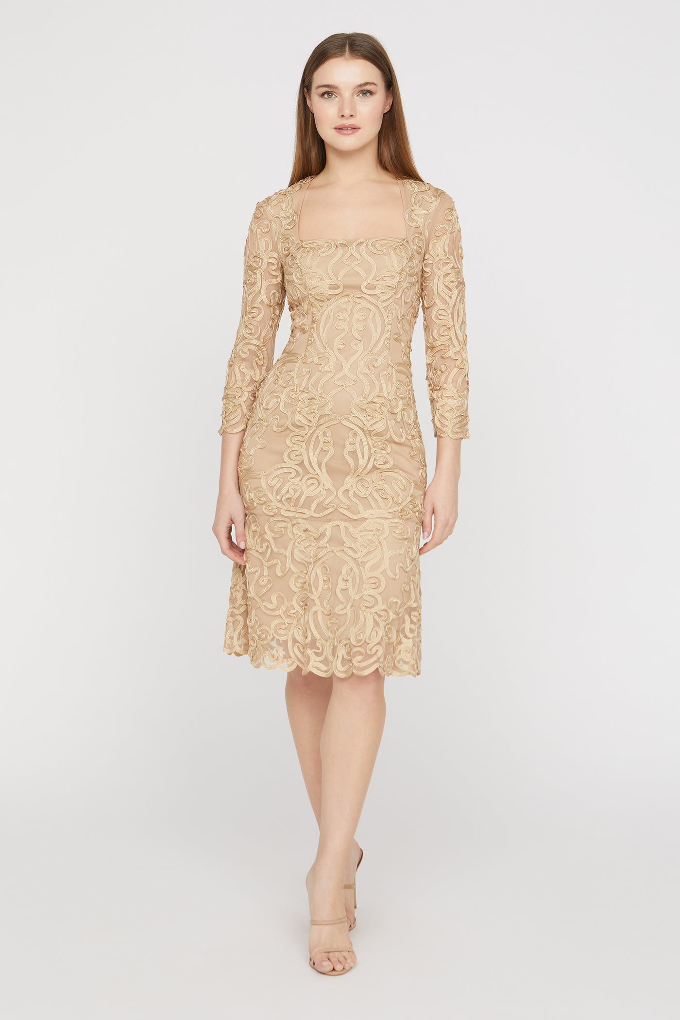 Woman wearing a beige lace dress on a white background