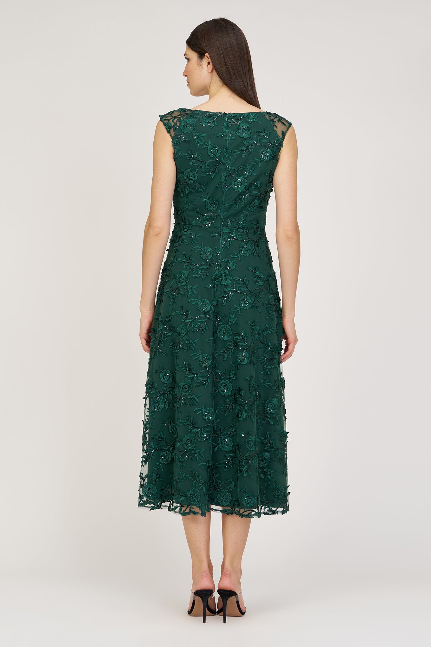 Green lace dress worn by a model on a white background