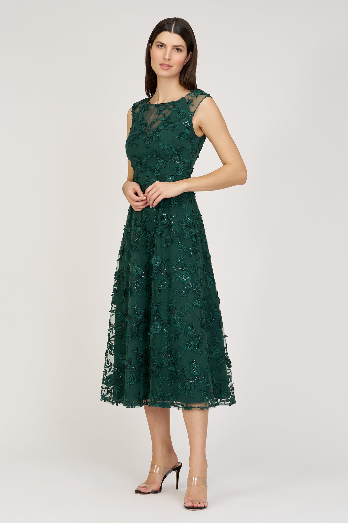 Woman wearing a green lace dress on a white background