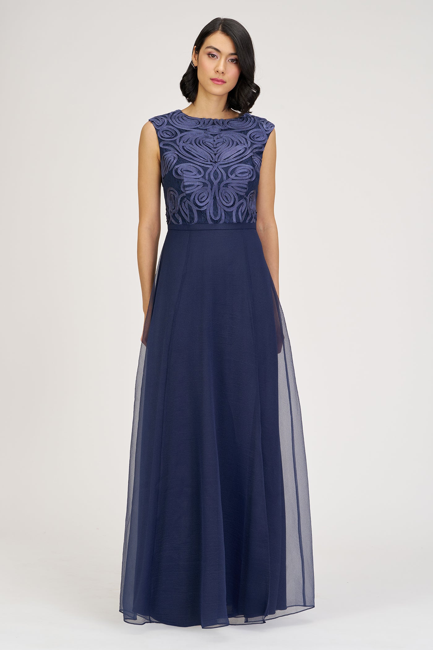 Navy blue evening gown with intricate top design on a white background