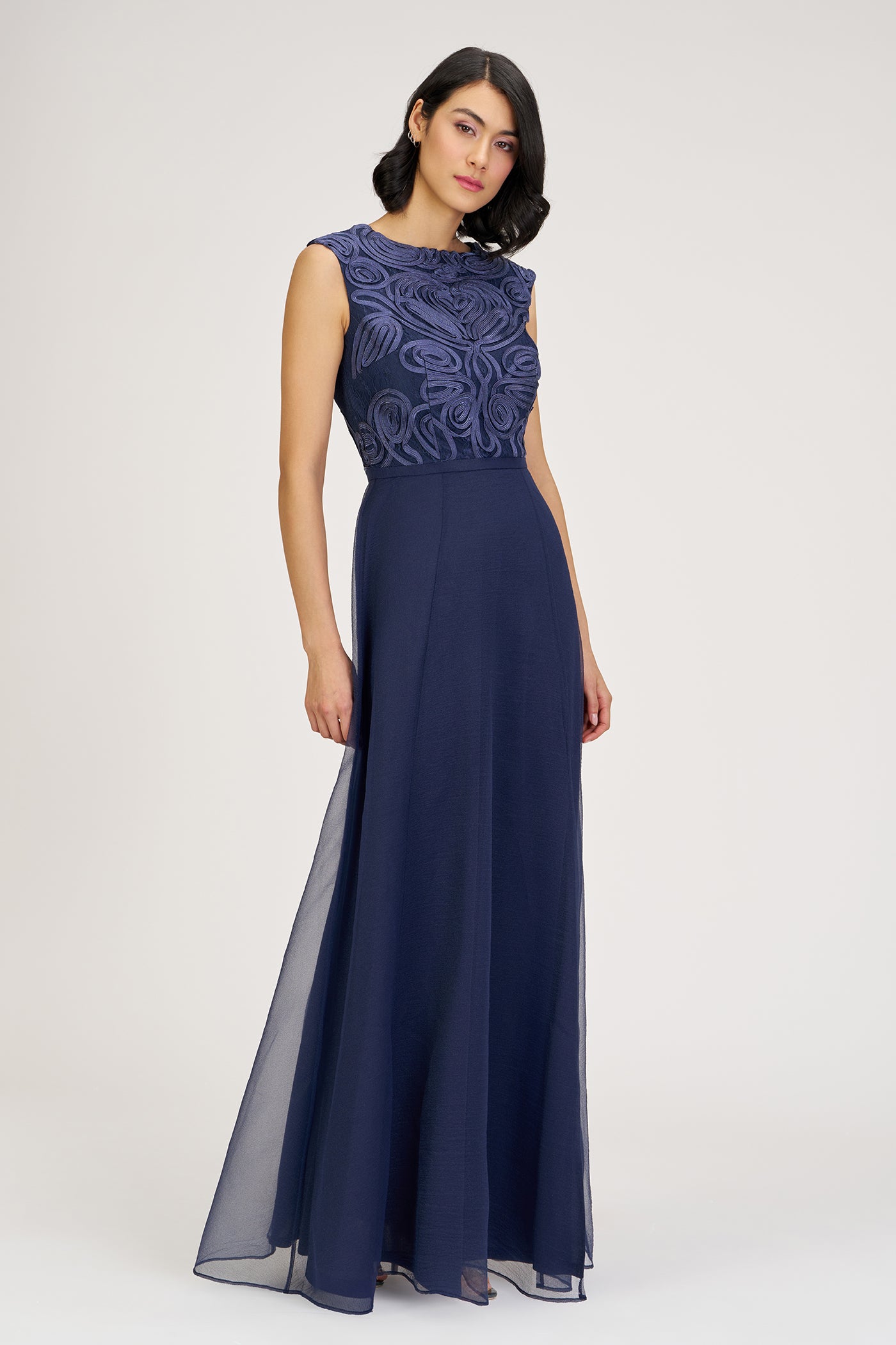 Navy evening gown with lace detailing on a white background