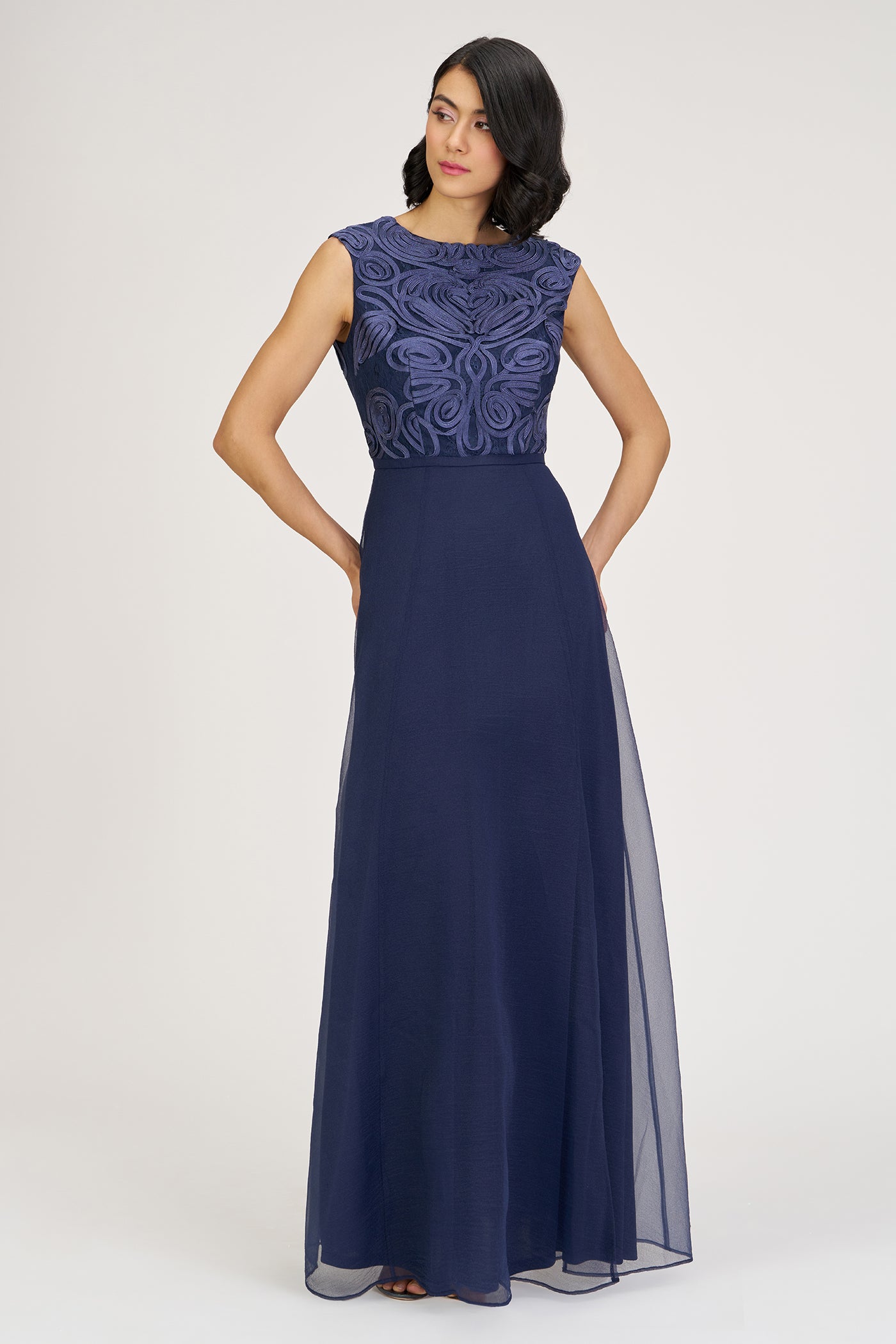 Navy blue evening gown with lace detailing on a white background