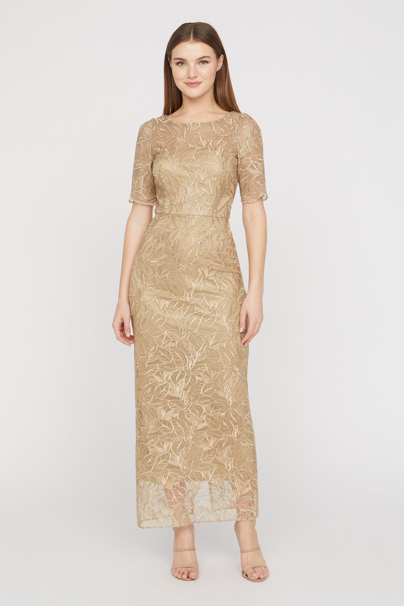 Woman wearing a gold lace dress on a white background