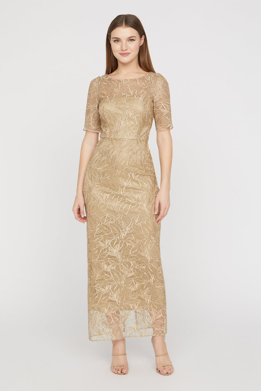 Woman wearing a gold lace dress on a white background