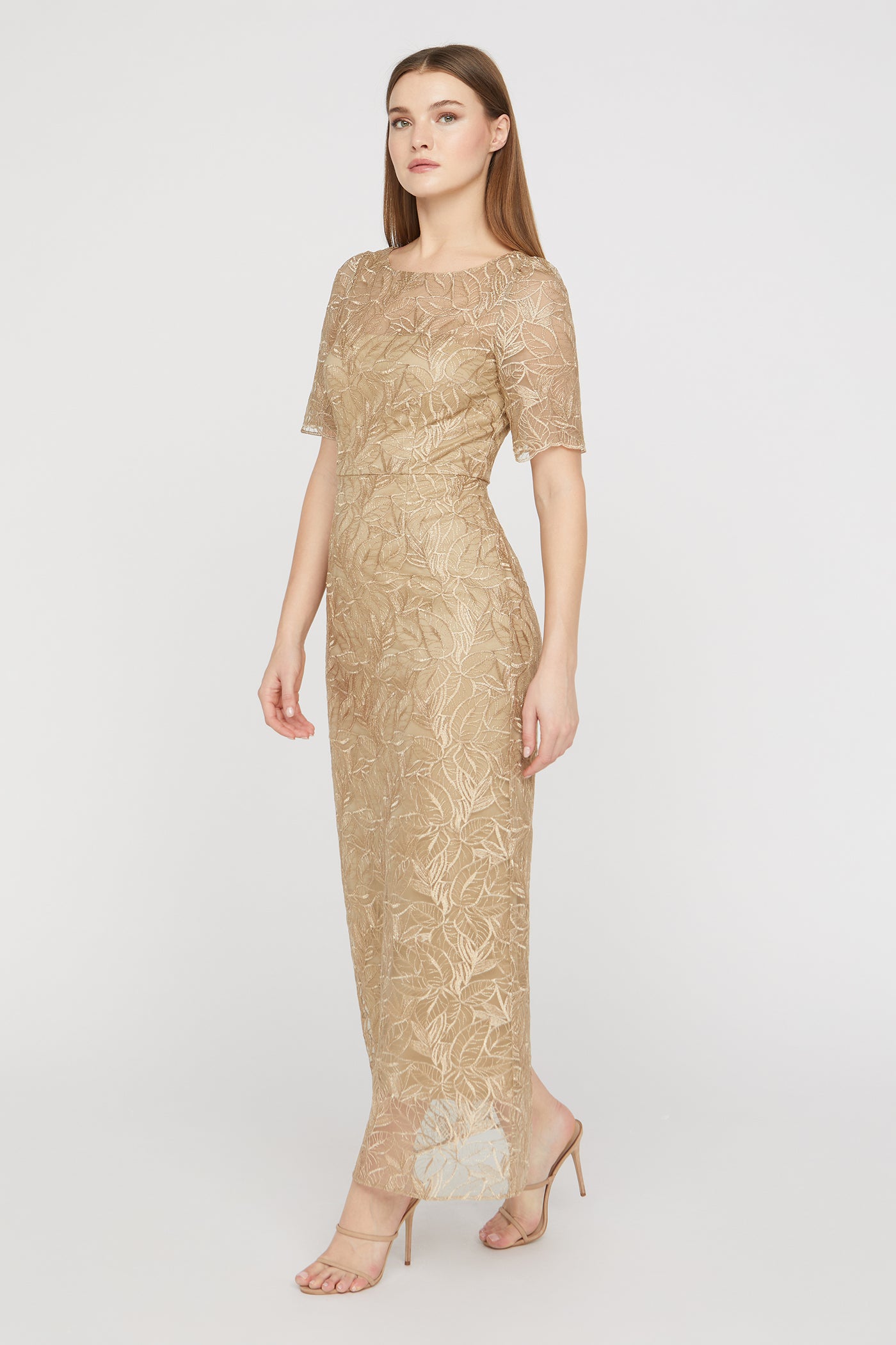 Woman wearing a gold lace dress on a white background