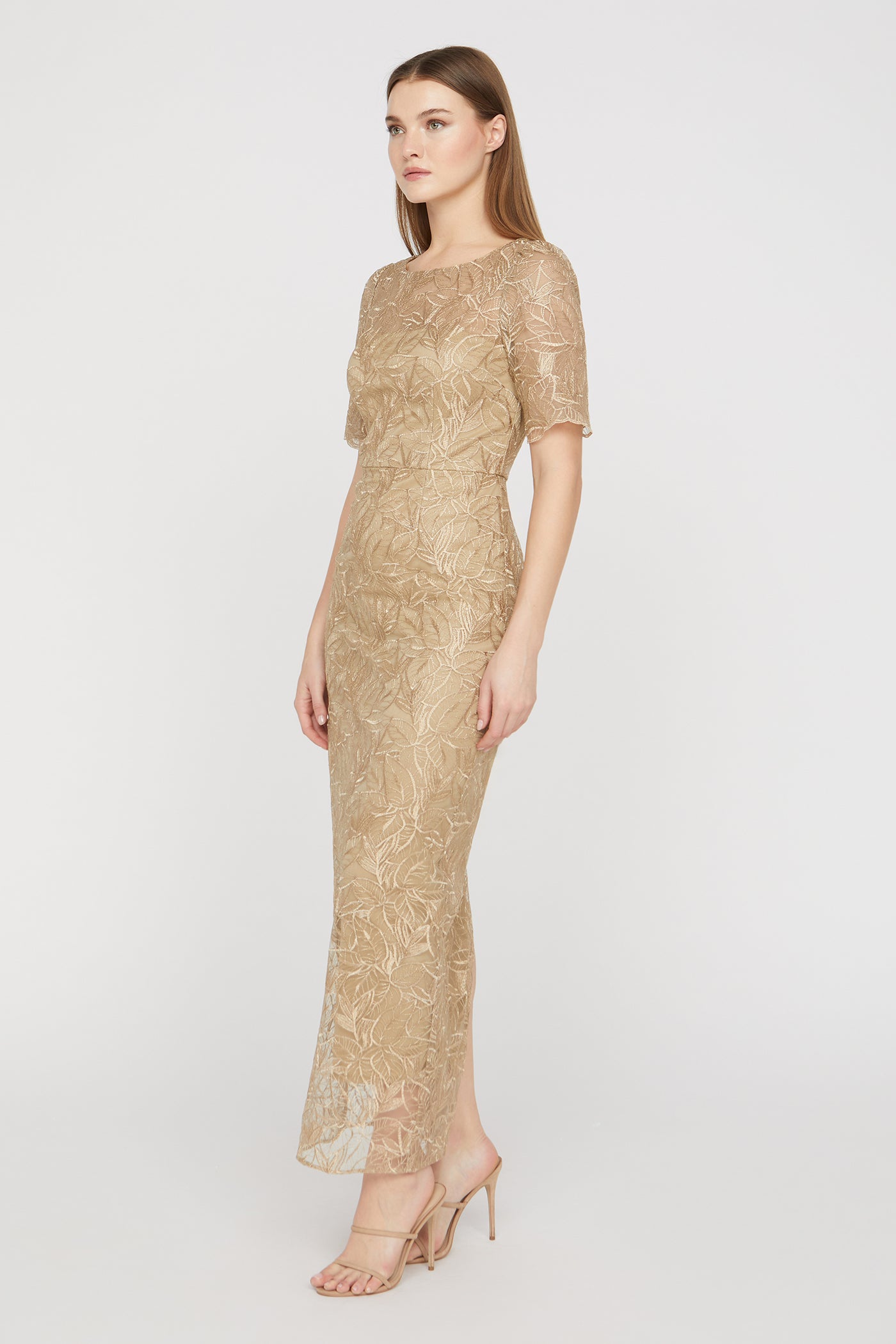 Woman wearing a gold lace dress on a white background