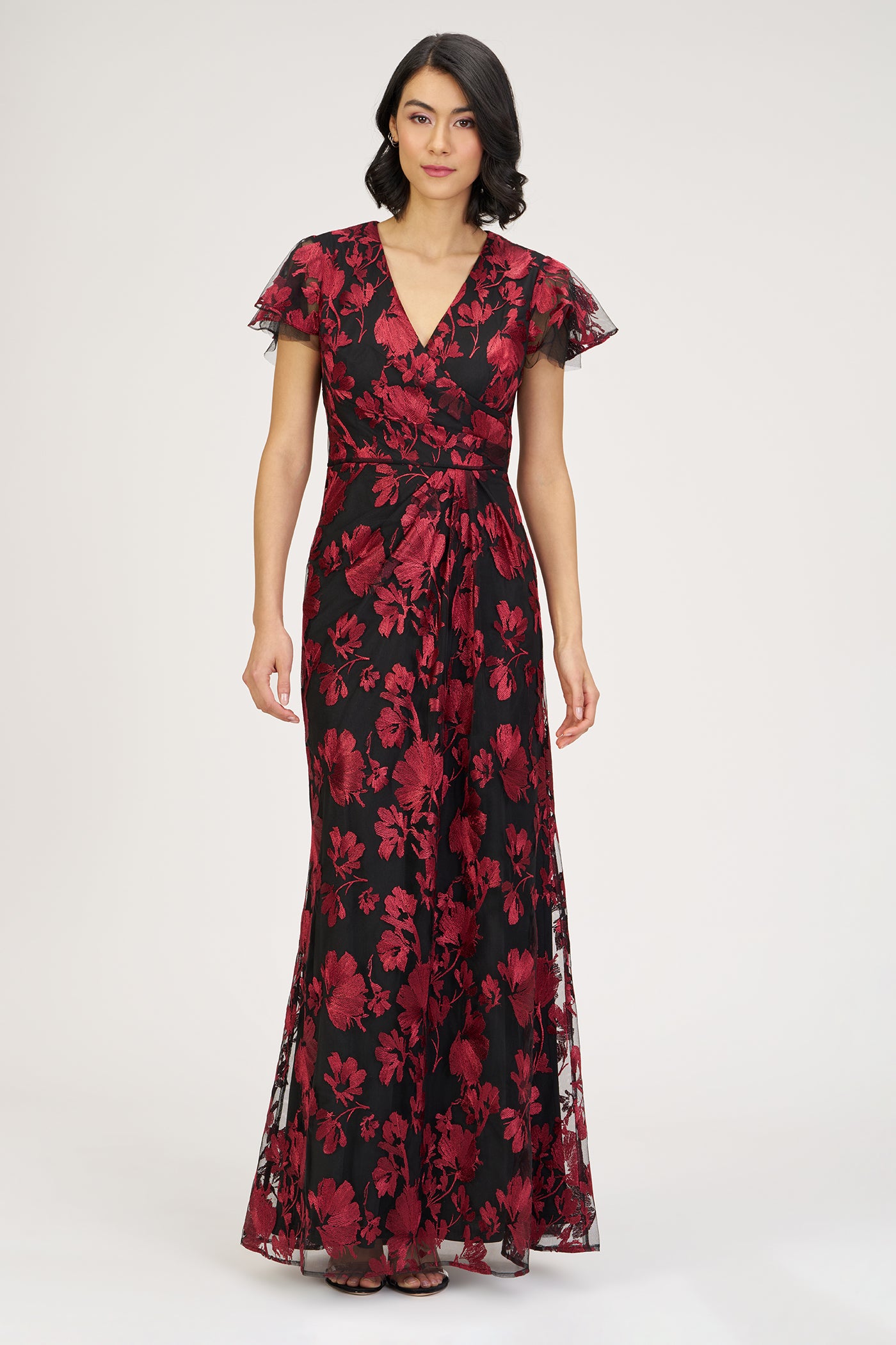 Woman wearing a red and black floral dress on a white background