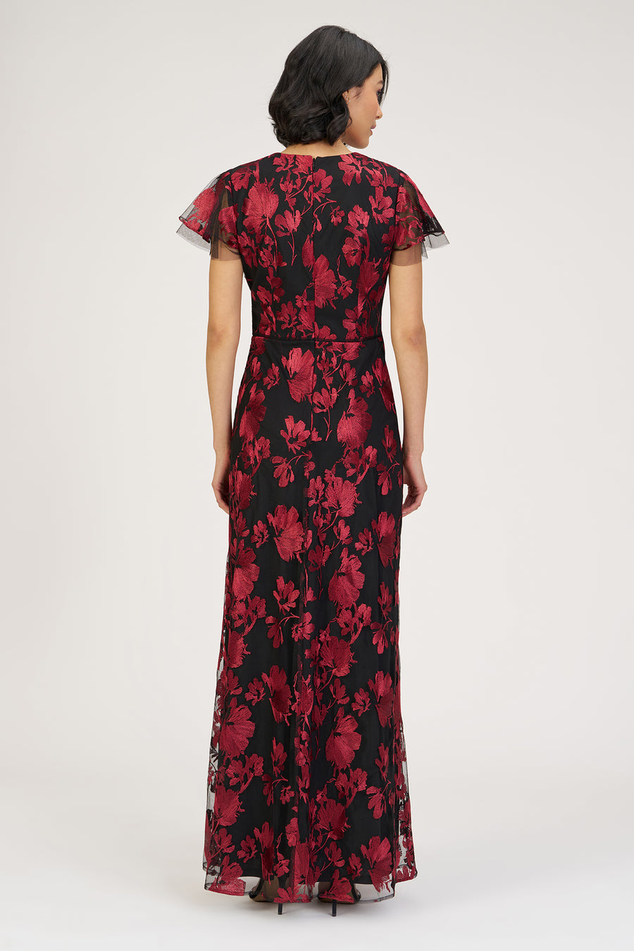 Woman wearing a black and red floral dress on a white background