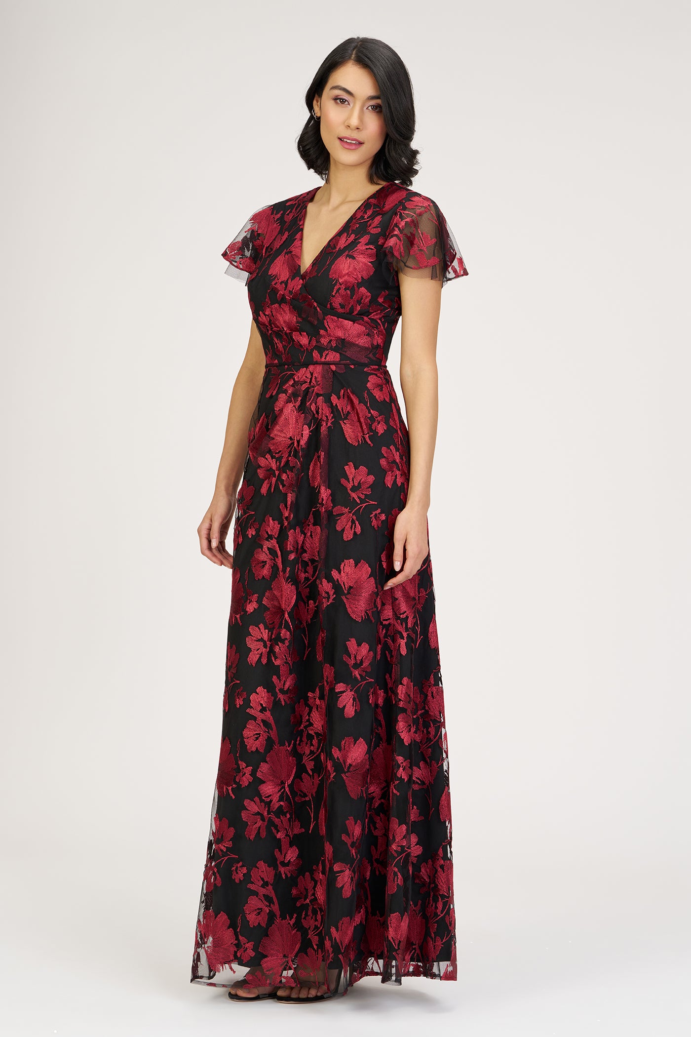 Woman wearing a red floral dress on a white background