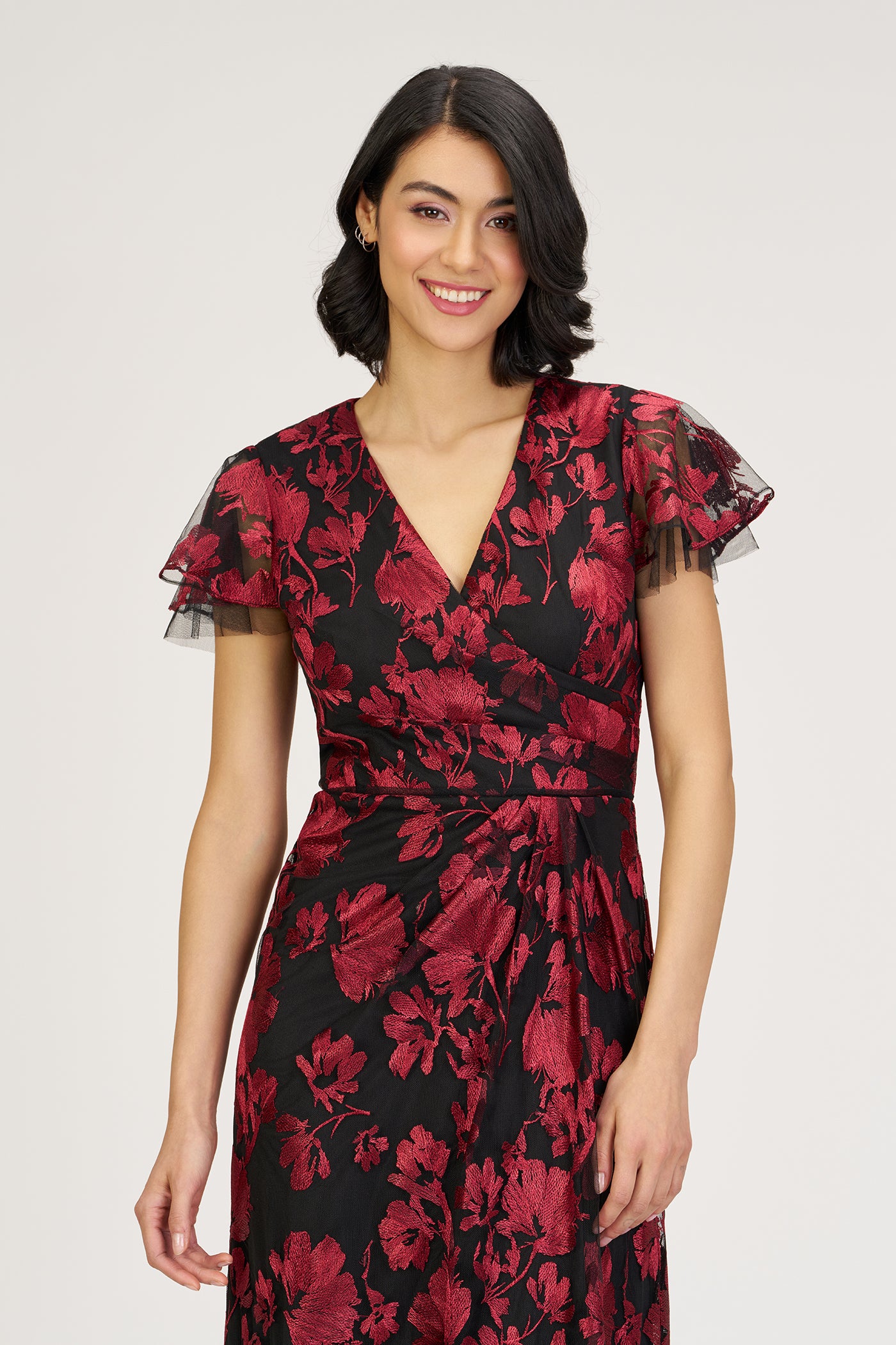 Woman wearing a black and red floral dress on a white background