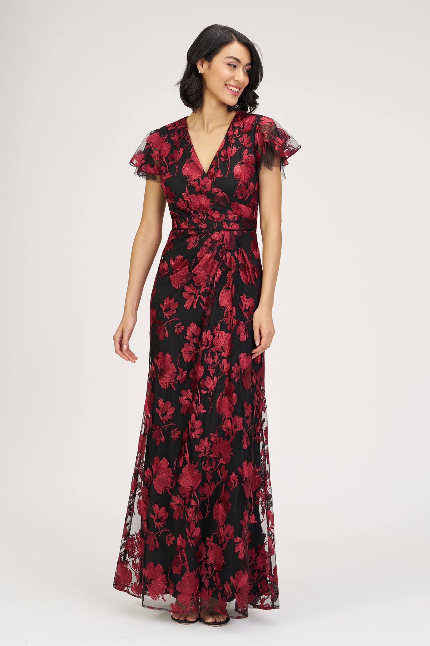 Woman wearing a red and black floral dress on a white background