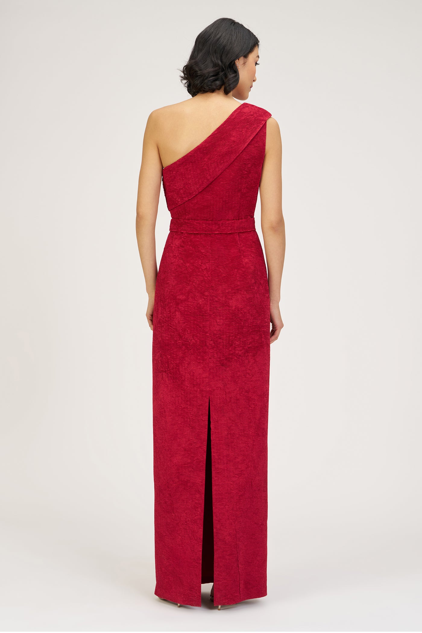 Woman wearing a red one-shoulder dress on a white background