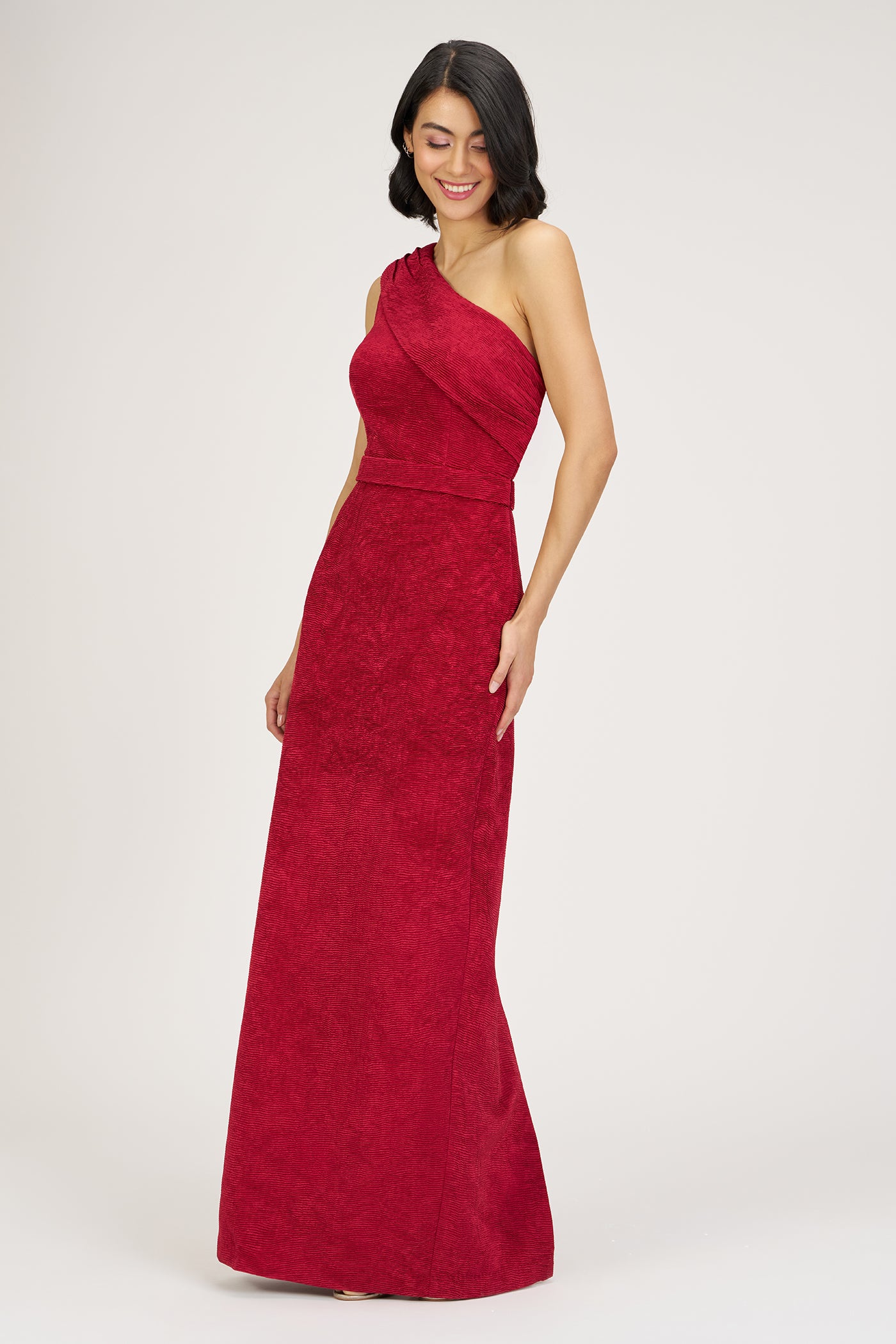 Woman wearing a red one-shoulder dress on a white background