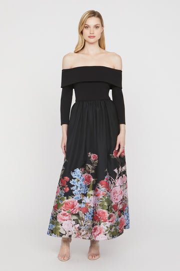 Woman wearing a black off-shoulder dress with a floral skirt on a white background