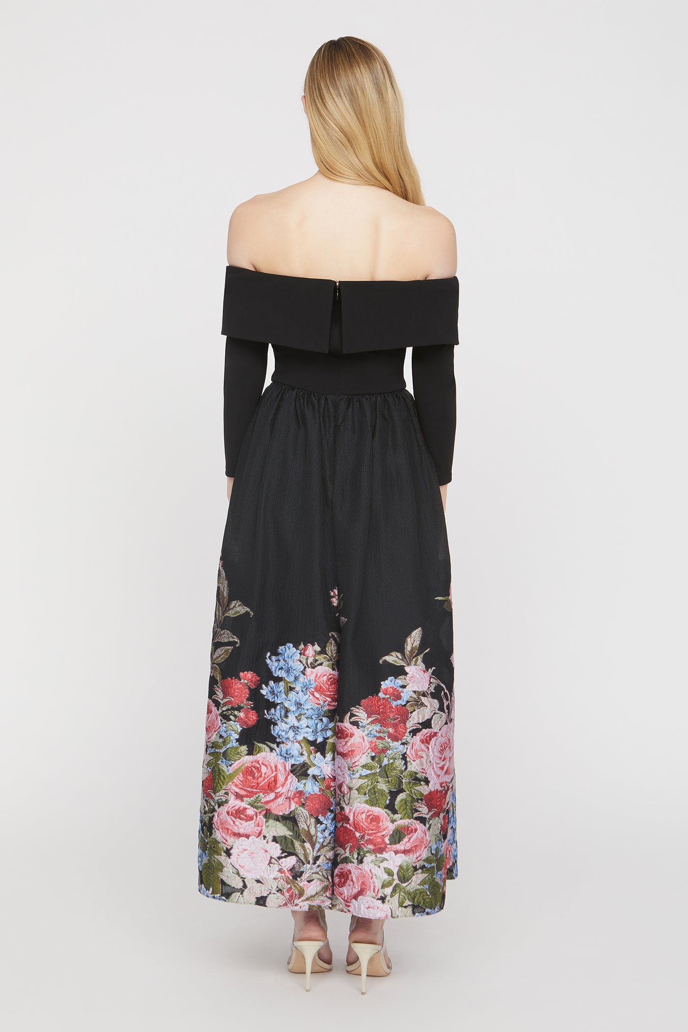 Black off-shoulder dress with floral patterns on a white background