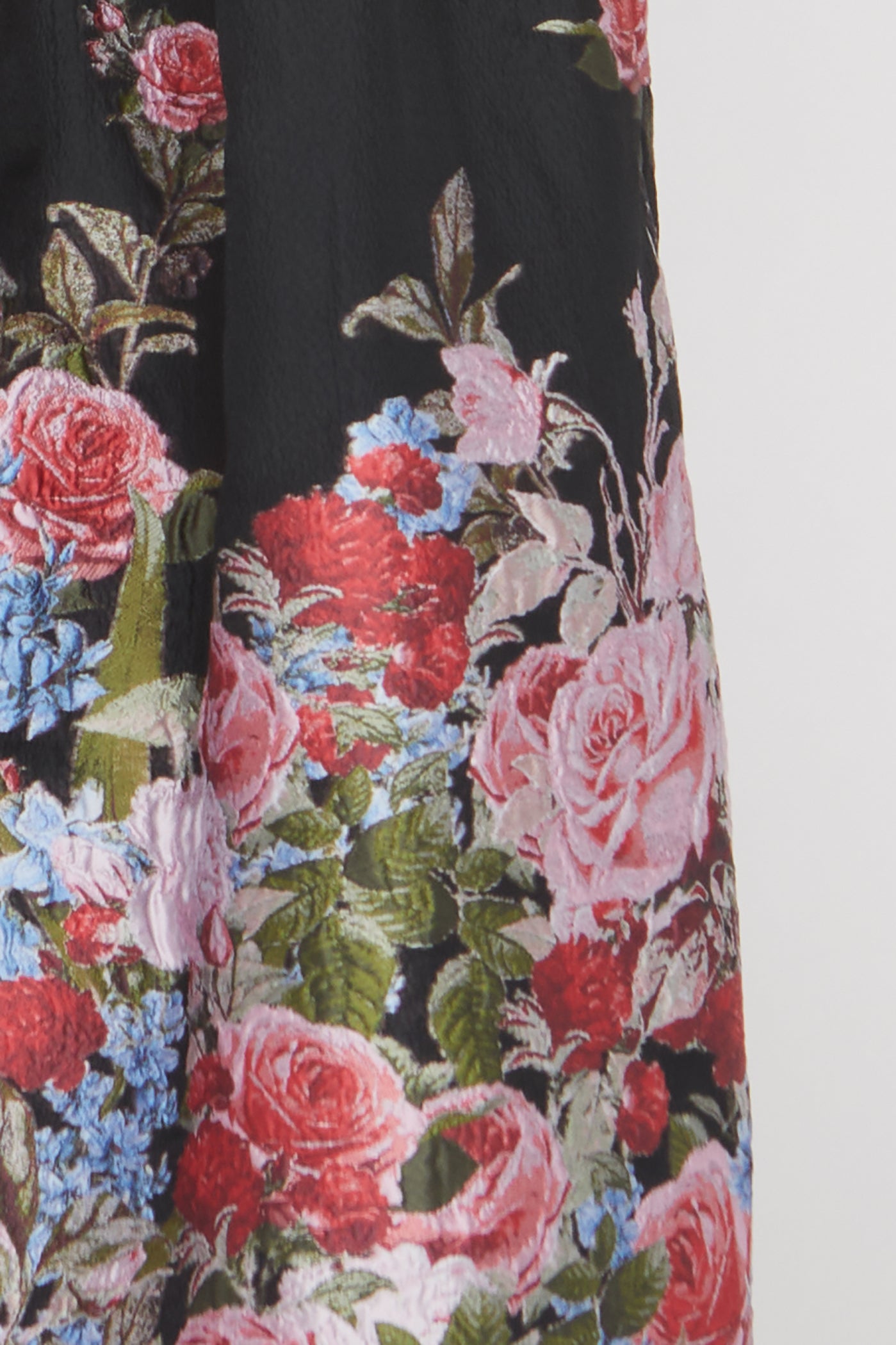 Floral patterned fabric with pink, red, and blue flowers on a black background