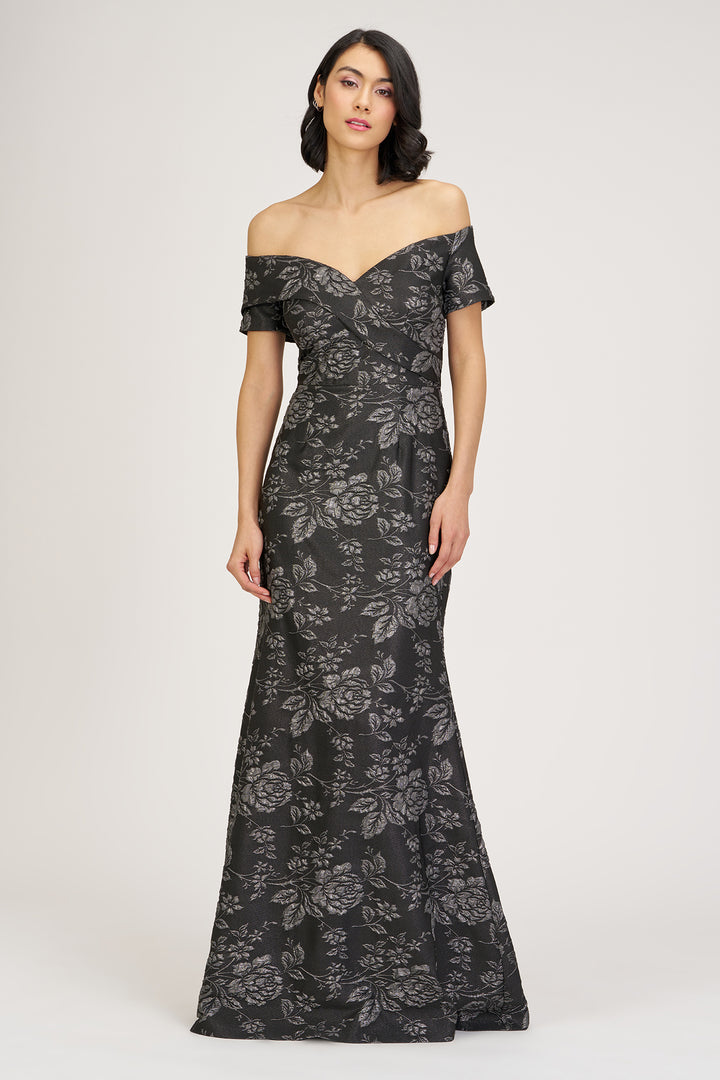 Woman wearing a black floral off-shoulder gown on a white background