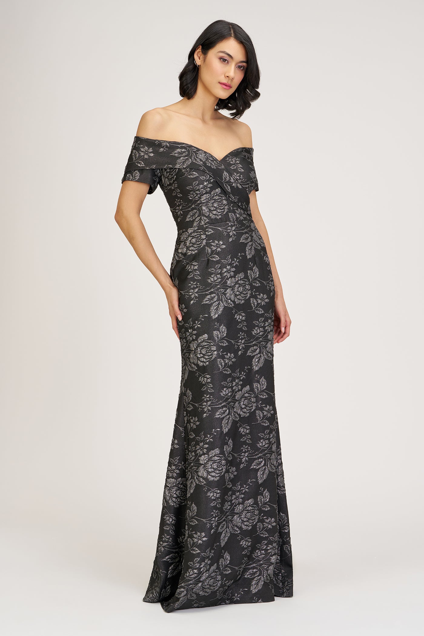 Woman wearing a black off-shoulder gown on a white background