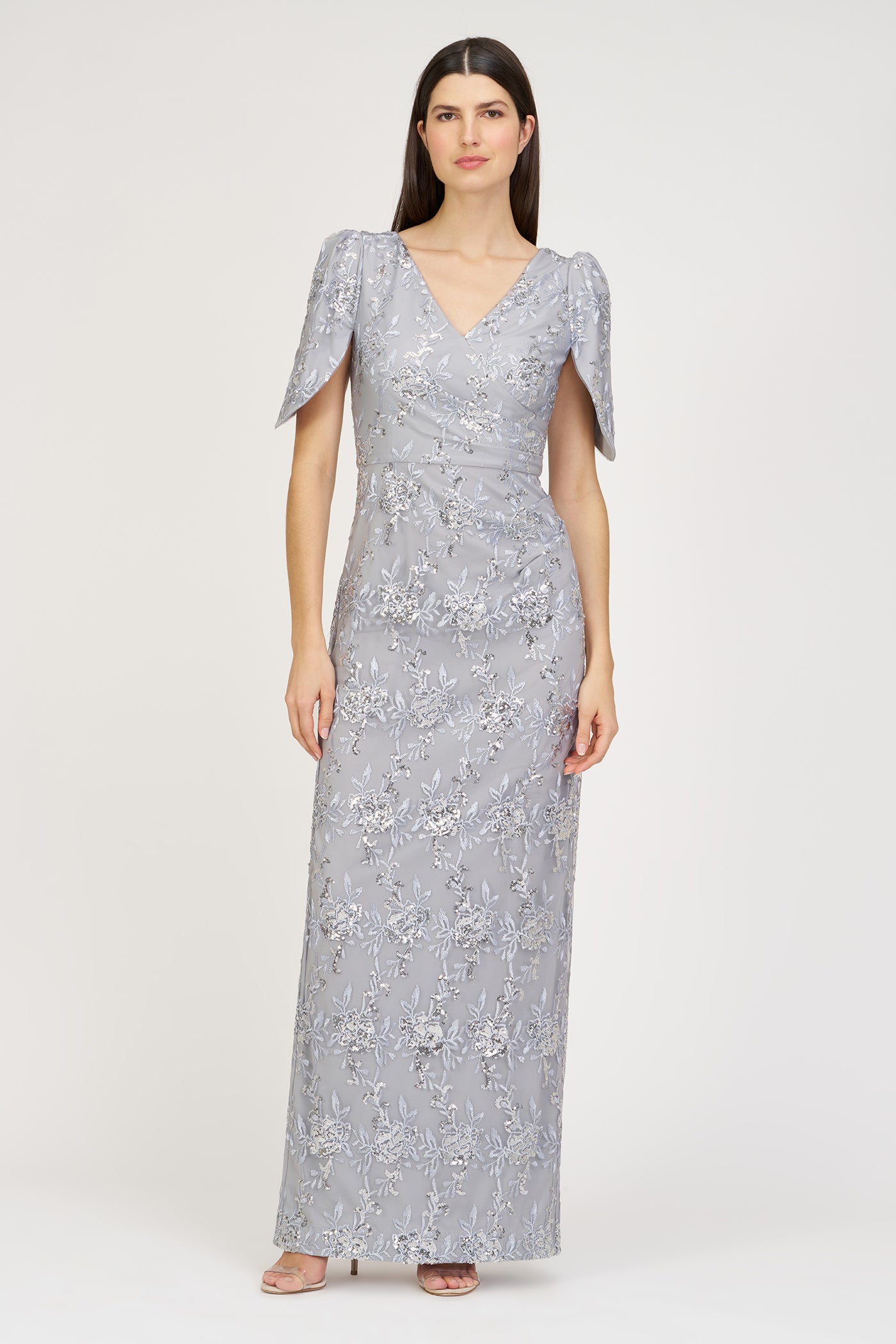 Woman wearing a silver sequin dress on a white background