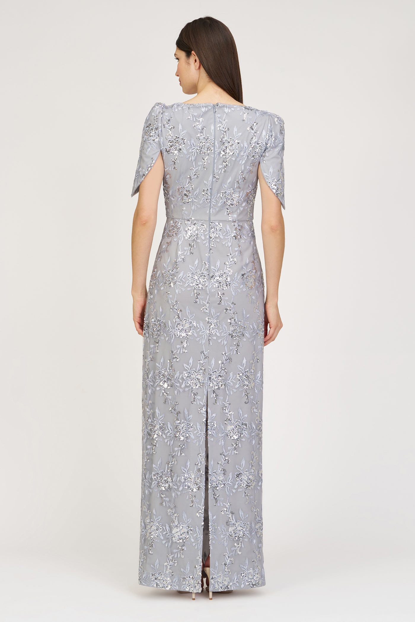 Woman wearing a silver sequin dress on a white background