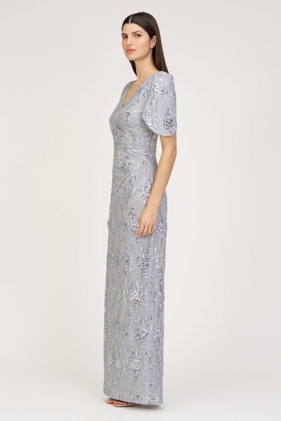 Woman wearing a silver sequin dress on a white background