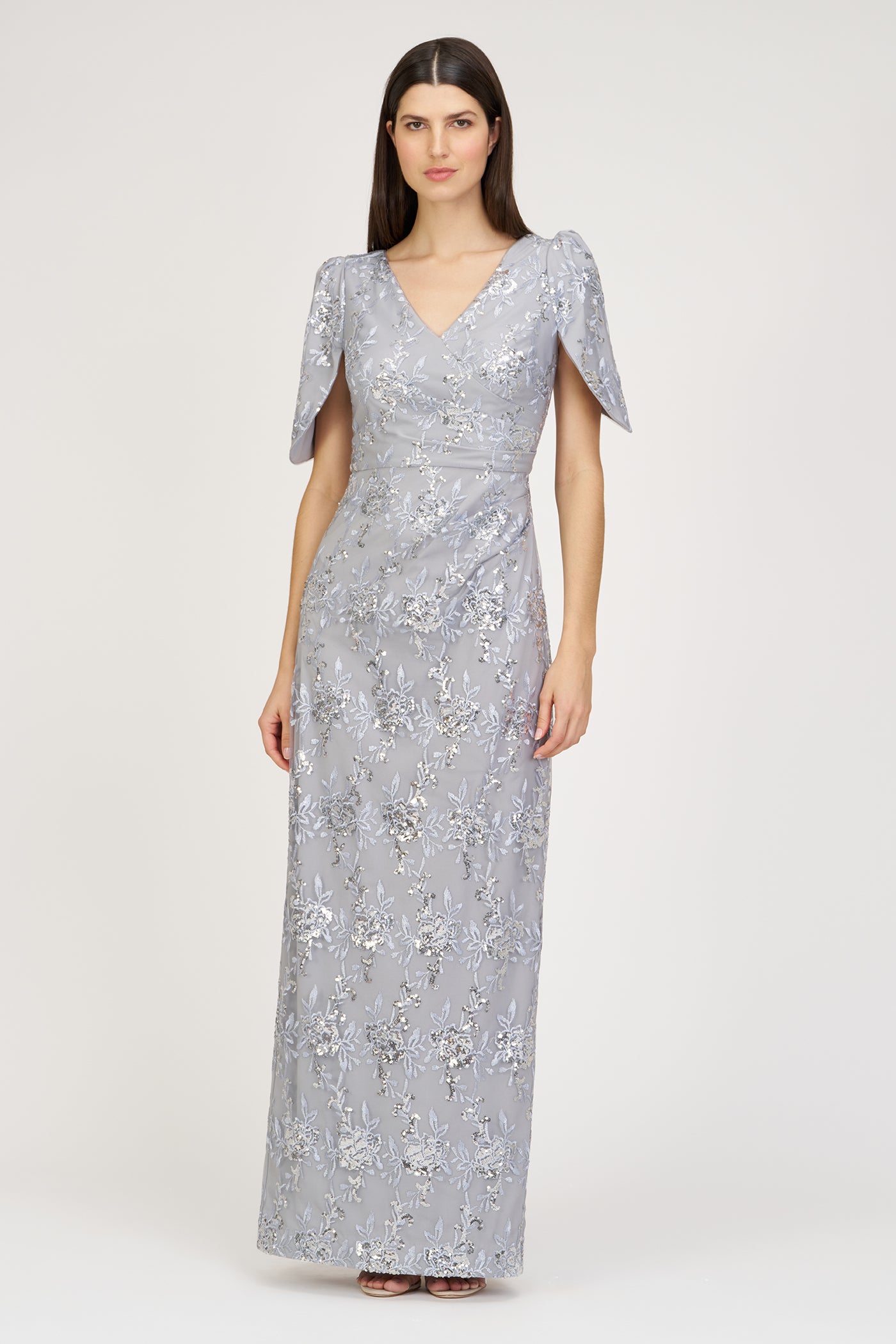 Woman wearing a silver sequin gown on a white background